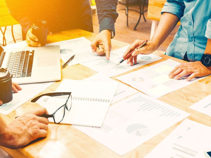 A team planning around a table of documents