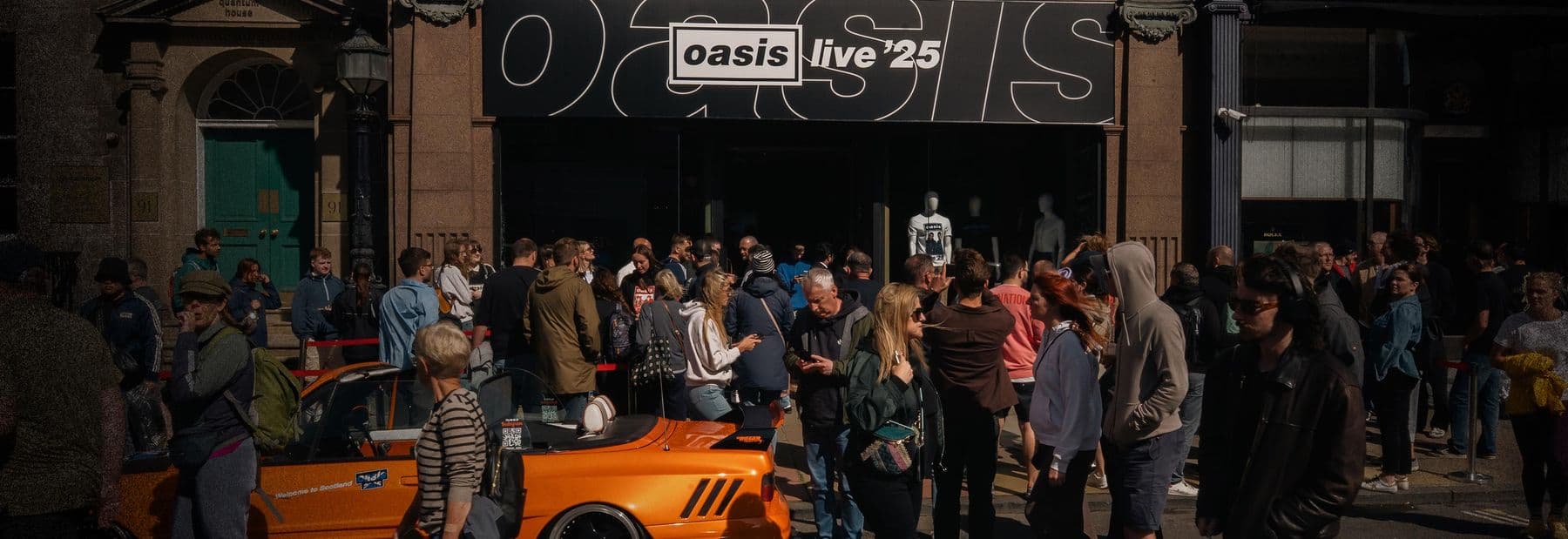 Crowd outside the Oasis Live '25 store at night